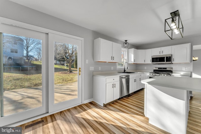 kitchen with sink, stainless steel appliances, light hardwood / wood-style floors, and white cabinets