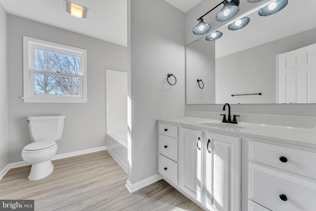 bathroom with vanity, toilet, and wood-type flooring