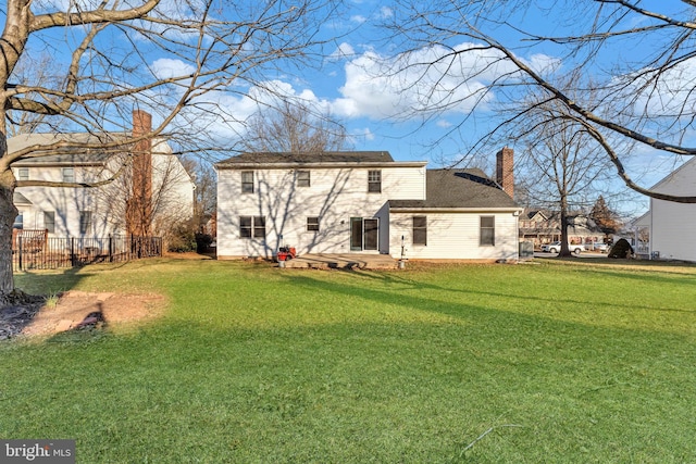 rear view of property featuring a yard