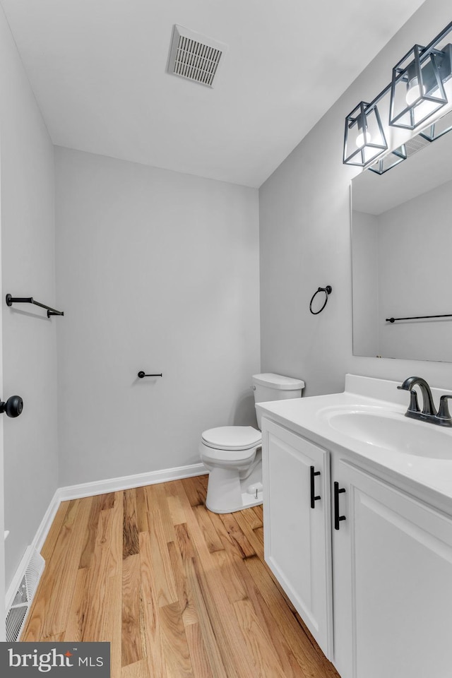 bathroom featuring hardwood / wood-style flooring, vanity, and toilet