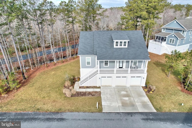 view of front of property with a garage, a front yard, and a porch