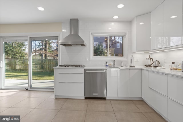 kitchen with wall chimney exhaust hood, appliances with stainless steel finishes, modern cabinets, and white cabinetry