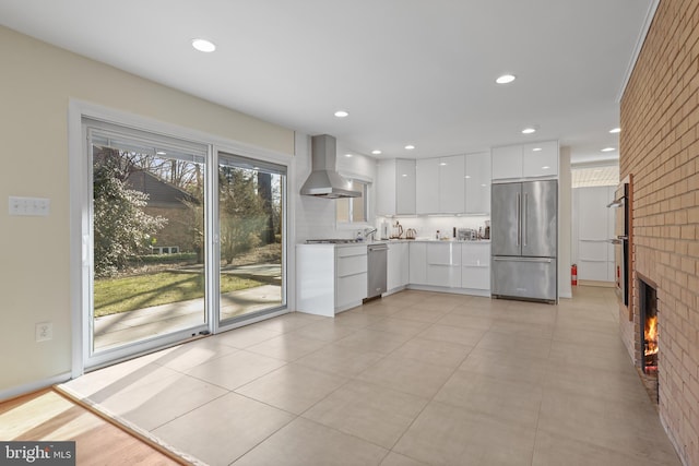 kitchen featuring island range hood, white cabinetry, light countertops, appliances with stainless steel finishes, and modern cabinets