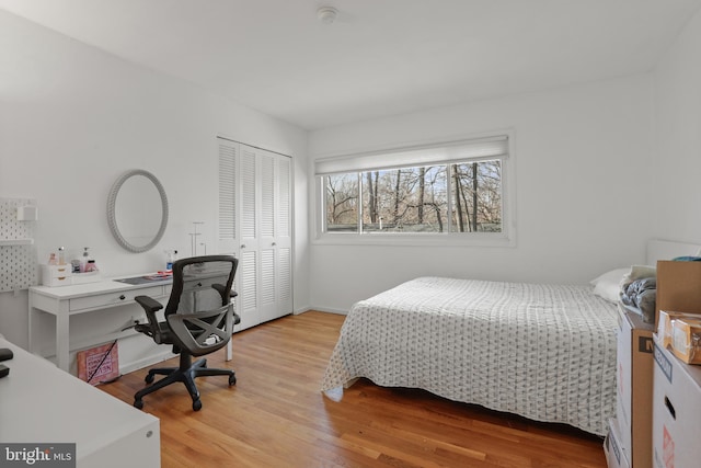 bedroom with light wood-style flooring and a closet