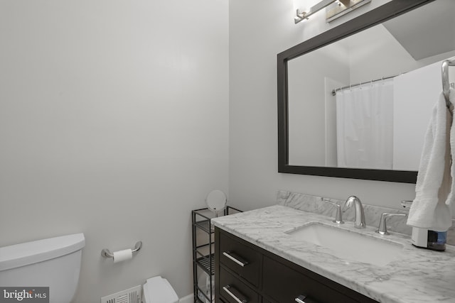 bathroom featuring toilet, visible vents, and vanity