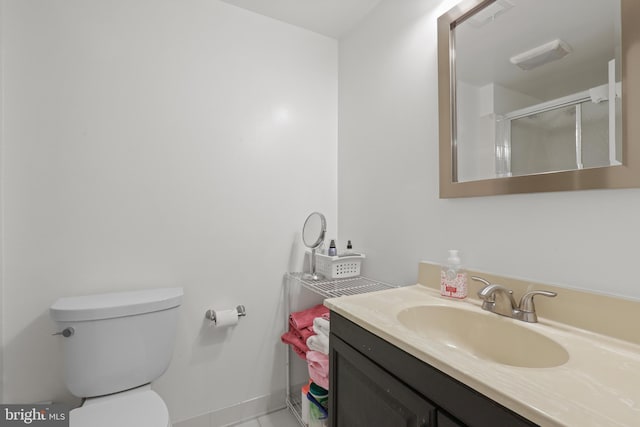 full bathroom with a stall shower, vanity, and toilet