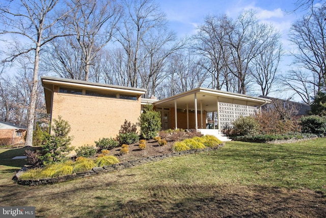 view of side of home with brick siding and a yard