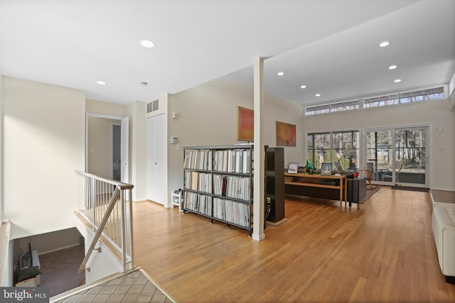 corridor featuring recessed lighting, visible vents, wood finished floors, and an upstairs landing