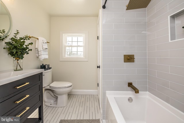 full bathroom featuring tiled shower / bath, vanity, and toilet