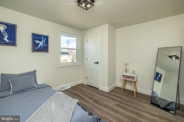 bedroom with dark hardwood / wood-style flooring