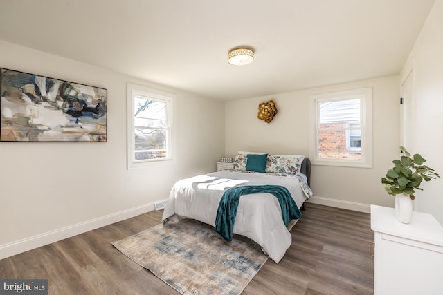 bedroom with multiple windows and hardwood / wood-style floors