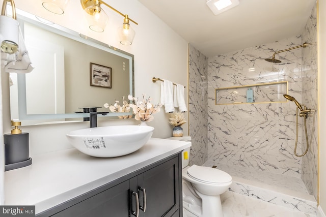 bathroom featuring vanity, toilet, and tiled shower