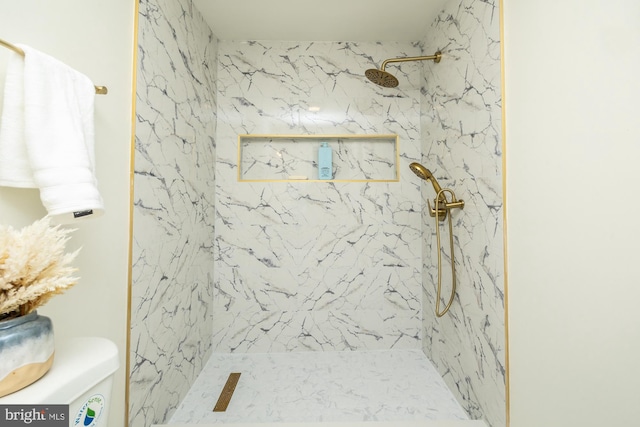 bathroom featuring tiled shower and toilet