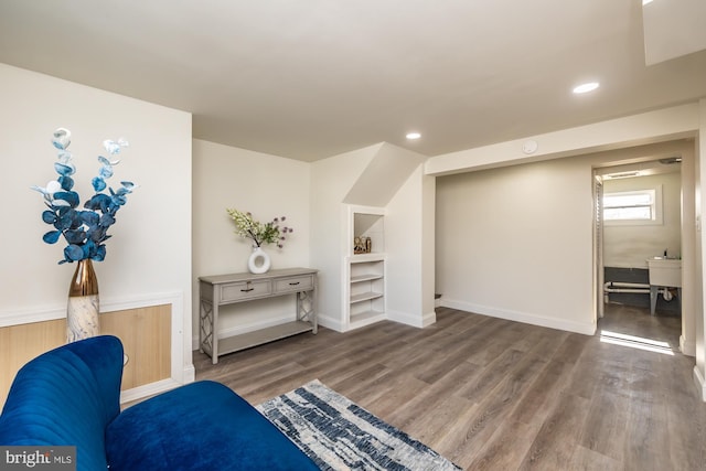 sitting room featuring hardwood / wood-style flooring and built in features