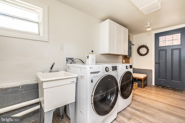 clothes washing area with cabinets, sink, light hardwood / wood-style floors, and washer and dryer