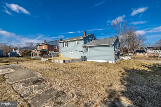 back of house with central AC unit, a yard, and a deck