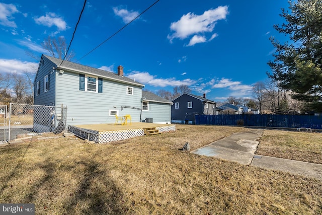 rear view of house featuring a deck and a lawn