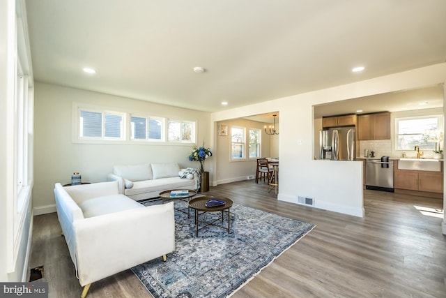 living room featuring dark hardwood / wood-style flooring, a chandelier, and a wealth of natural light