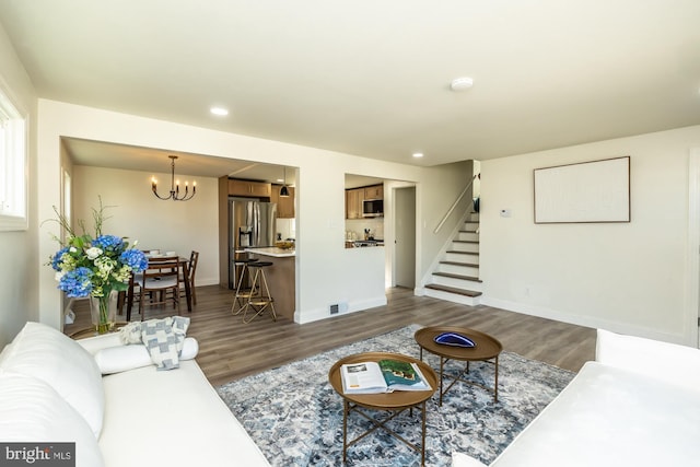 living room with dark hardwood / wood-style flooring and a notable chandelier