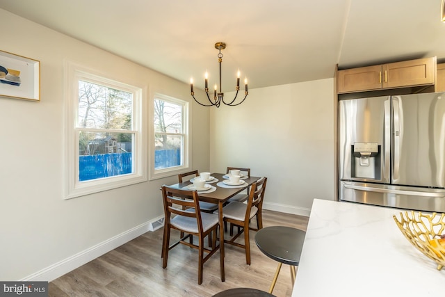 dining space featuring hardwood / wood-style flooring and an inviting chandelier