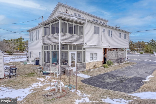 back of property with a sunroom