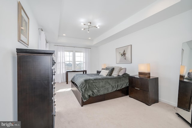 bedroom featuring light carpet and a tray ceiling