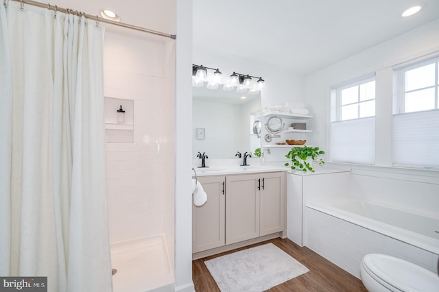 full bathroom with hardwood / wood-style flooring, vanity, separate shower and tub, and toilet