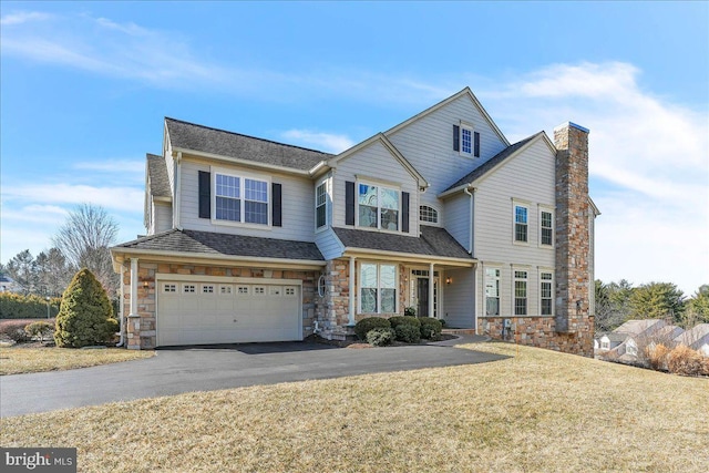 view of front of home with roof with shingles, a chimney, a front yard, a garage, and driveway