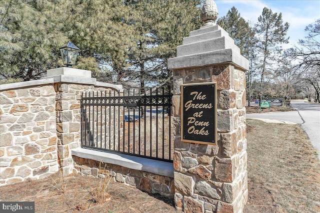 community sign featuring fence and a gate