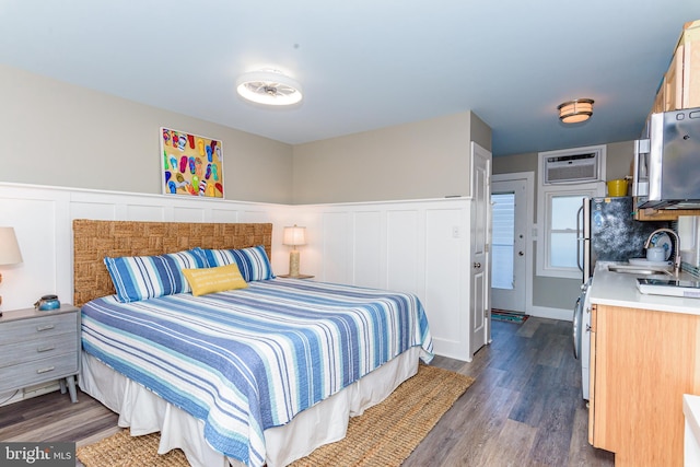 bedroom featuring an AC wall unit, sink, and dark wood-type flooring