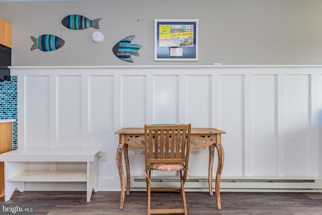 dining area featuring dark hardwood / wood-style flooring and a baseboard heating unit