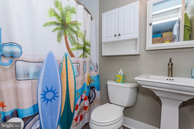 bathroom featuring a shower with shower curtain and toilet