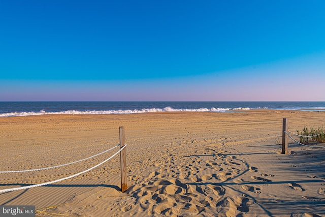 view of community with a water view and a beach view