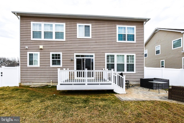 back of house with a deck, an outdoor hangout area, fence, a lawn, and a patio area