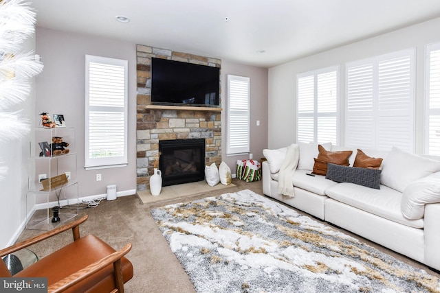 living room with baseboards, light colored carpet, and a stone fireplace