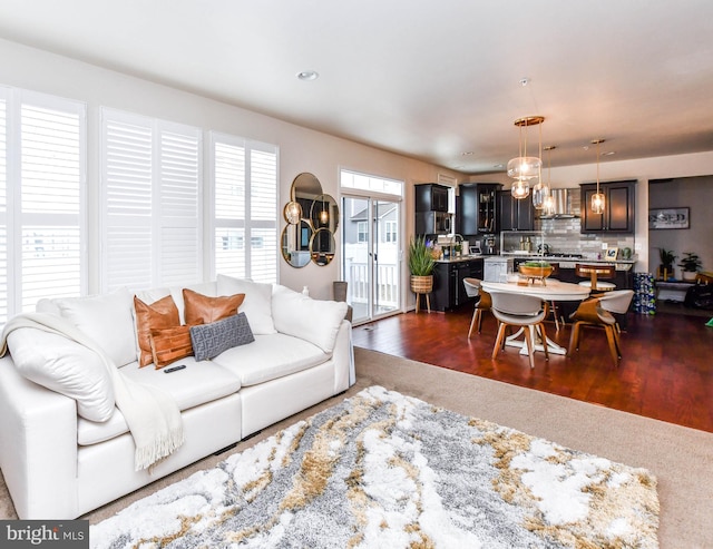 living room with dark wood-style floors and recessed lighting