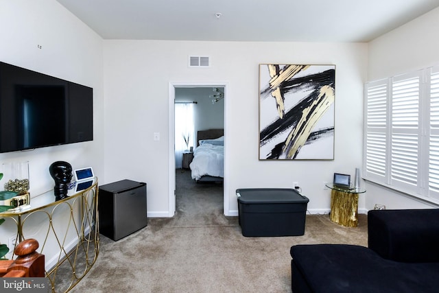 living area with light carpet, plenty of natural light, and visible vents