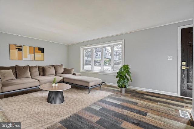 living room featuring hardwood / wood-style flooring and crown molding