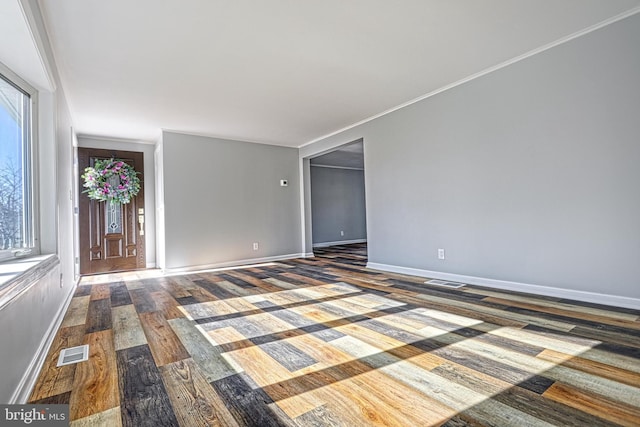 empty room featuring ornamental molding and dark hardwood / wood-style flooring