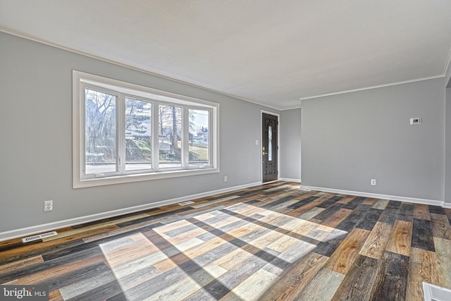 empty room featuring crown molding and dark wood-type flooring