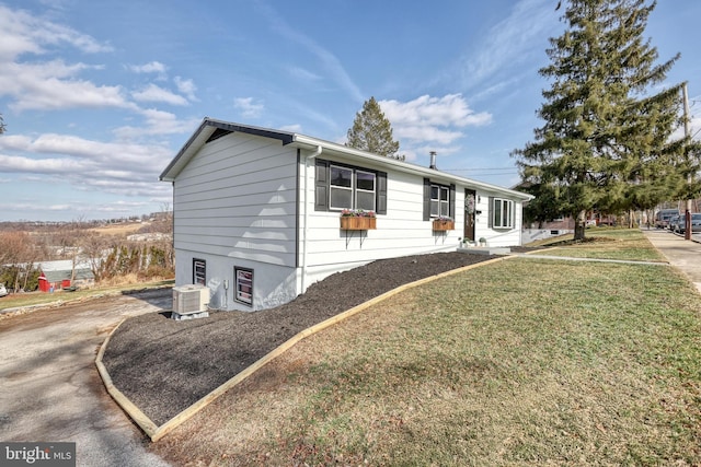 view of front of house with a front yard and central air condition unit