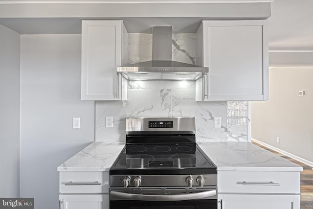 kitchen featuring white cabinets, stainless steel range with electric cooktop, light stone counters, and wall chimney exhaust hood