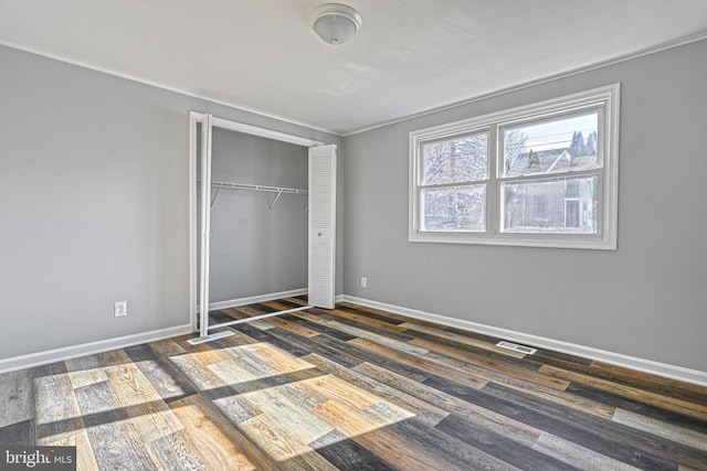 unfurnished bedroom with dark wood-type flooring and a closet