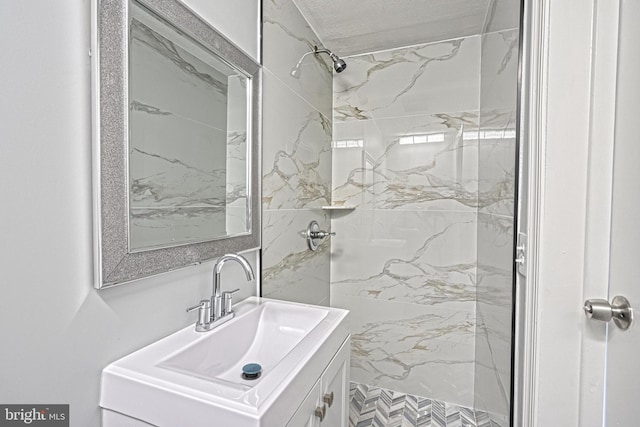 bathroom with vanity and tiled shower