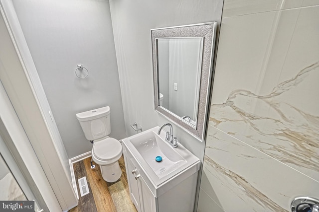 bathroom featuring vanity, toilet, and hardwood / wood-style floors