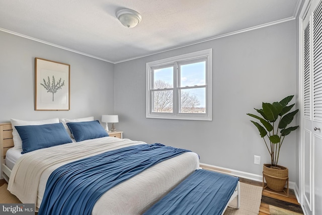 bedroom with crown molding, hardwood / wood-style flooring, a closet, and a textured ceiling