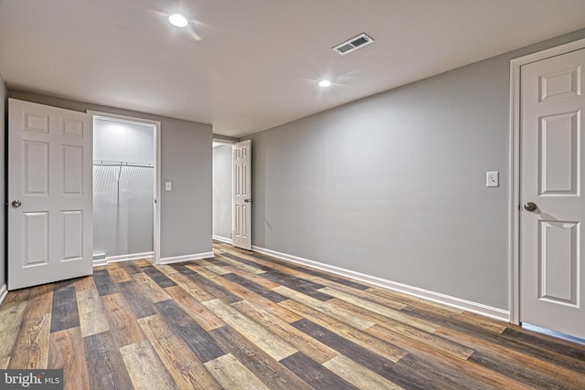 unfurnished bedroom with a closet and dark hardwood / wood-style floors