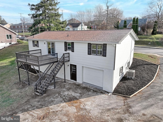 rear view of property featuring a garage, central AC, and a deck