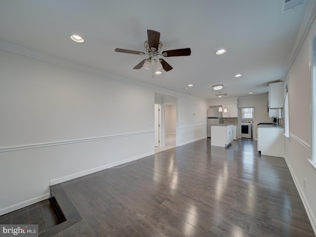 unfurnished living room featuring sink, crown molding, dark wood-type flooring, and ceiling fan