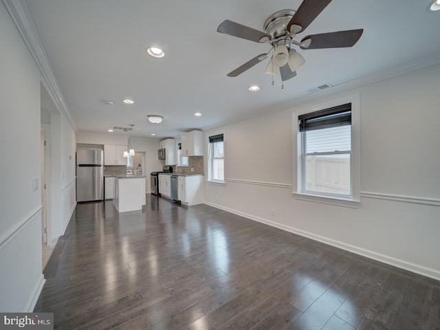 unfurnished living room featuring dark wood-type flooring, ceiling fan, ornamental molding, and sink